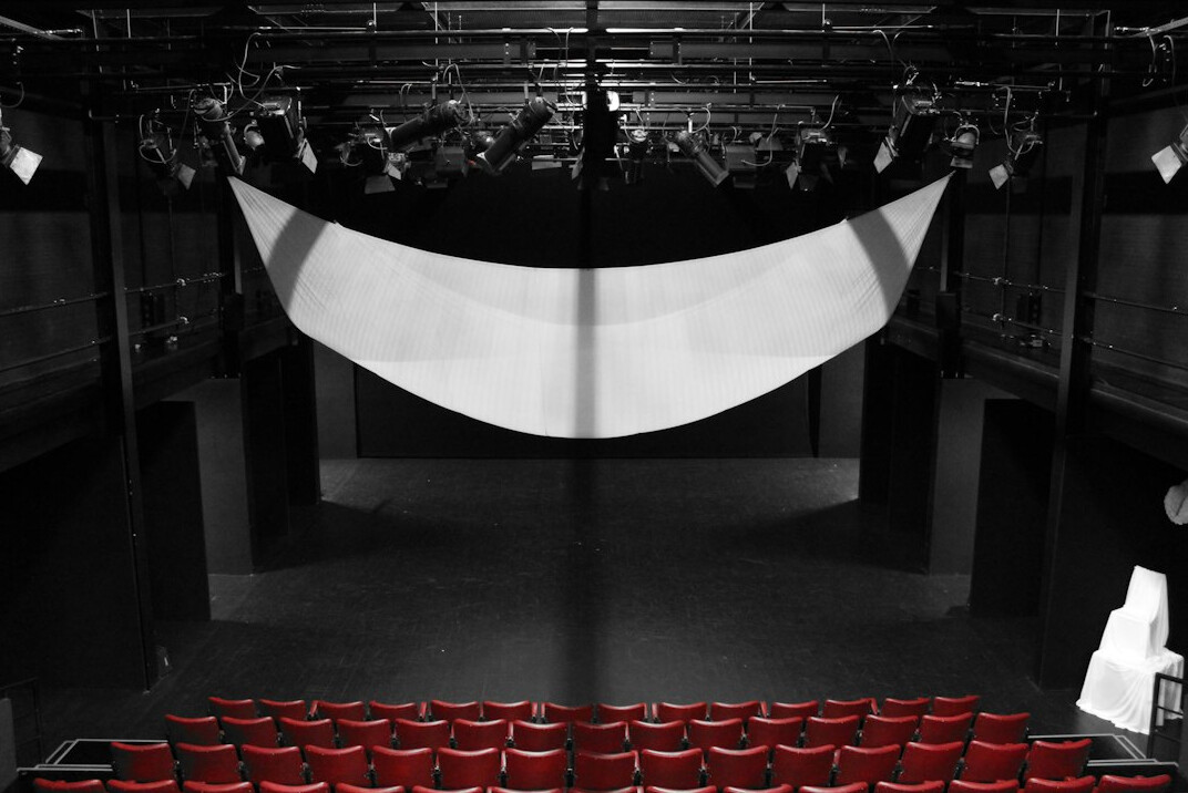 Audience watching a stage performance in a small theatre